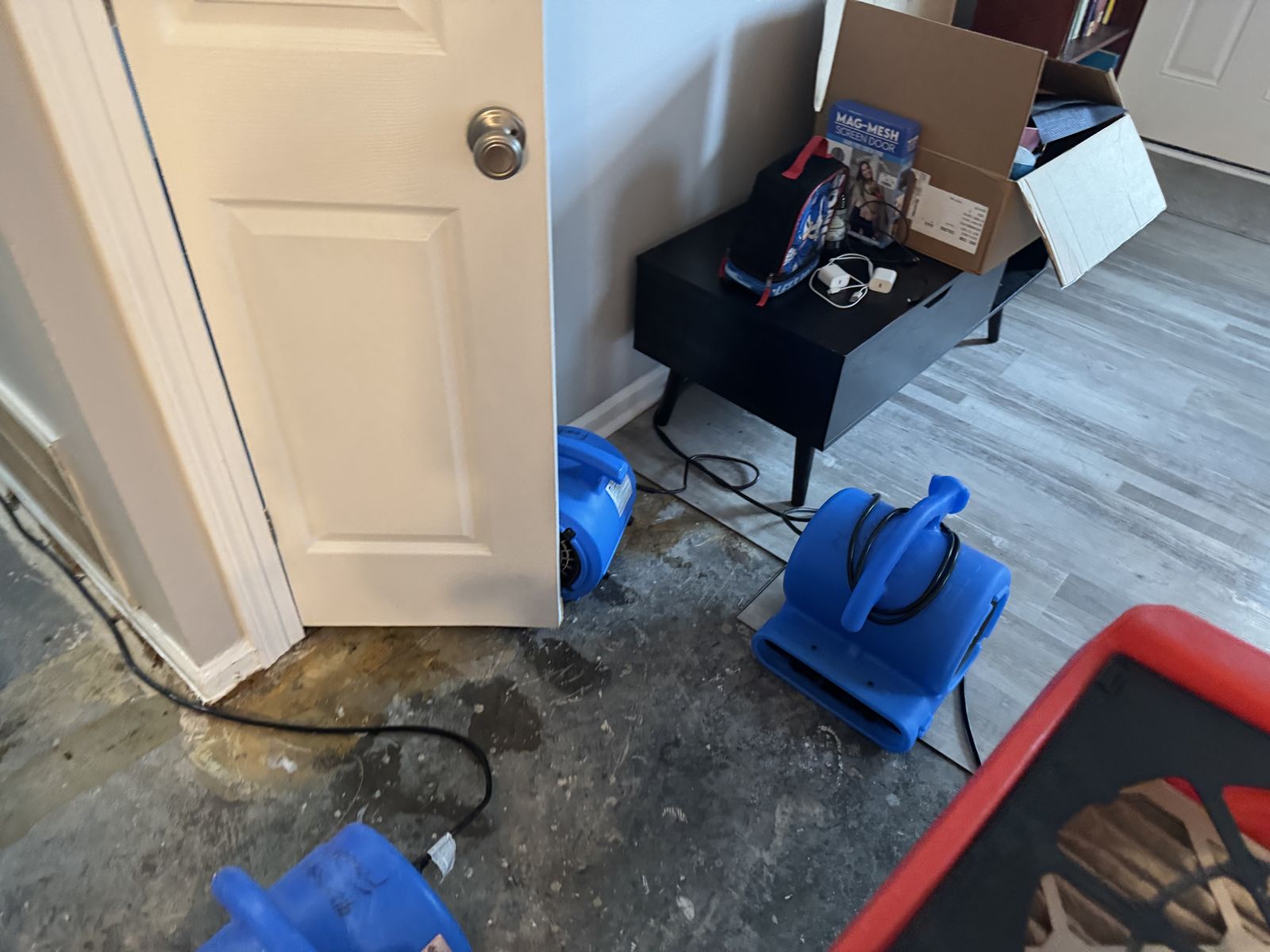 Air movers drying a water-damaged floor